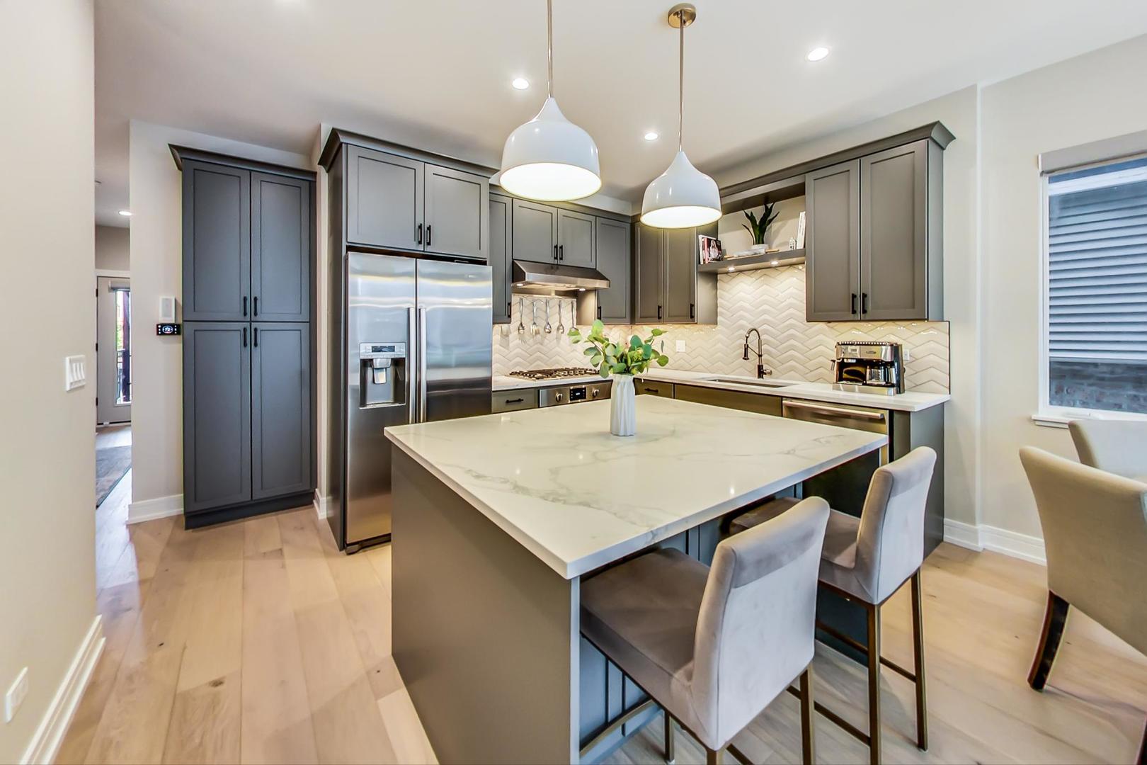 728 North Elizabeth Street, Unit 1 Chicago, IL 60642 - Photo 6 of 27 a kitchen with a table chairs refrigerator and microwave