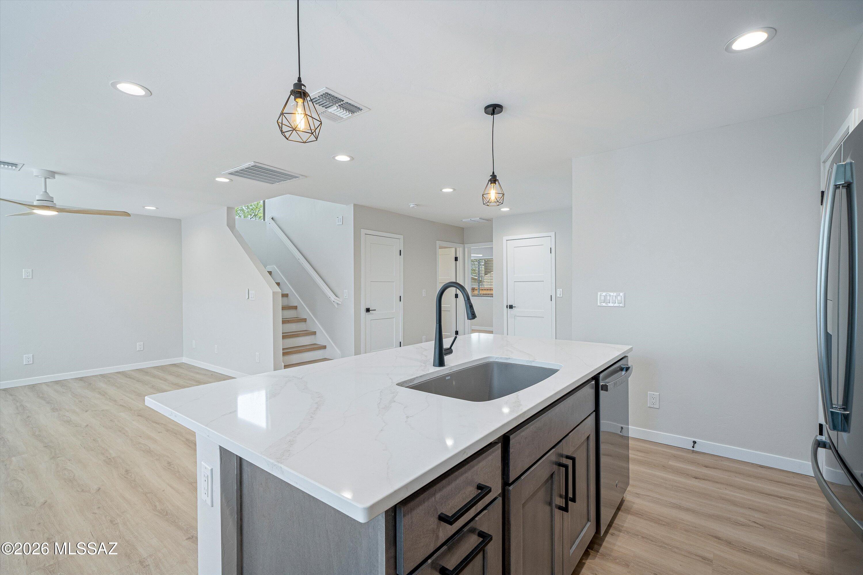 739 North Queen Avenue, Unit 2 Tucson, AZ 85705 - Photo 22 of 28 a kitchen with a sink a counter space and a chandelier