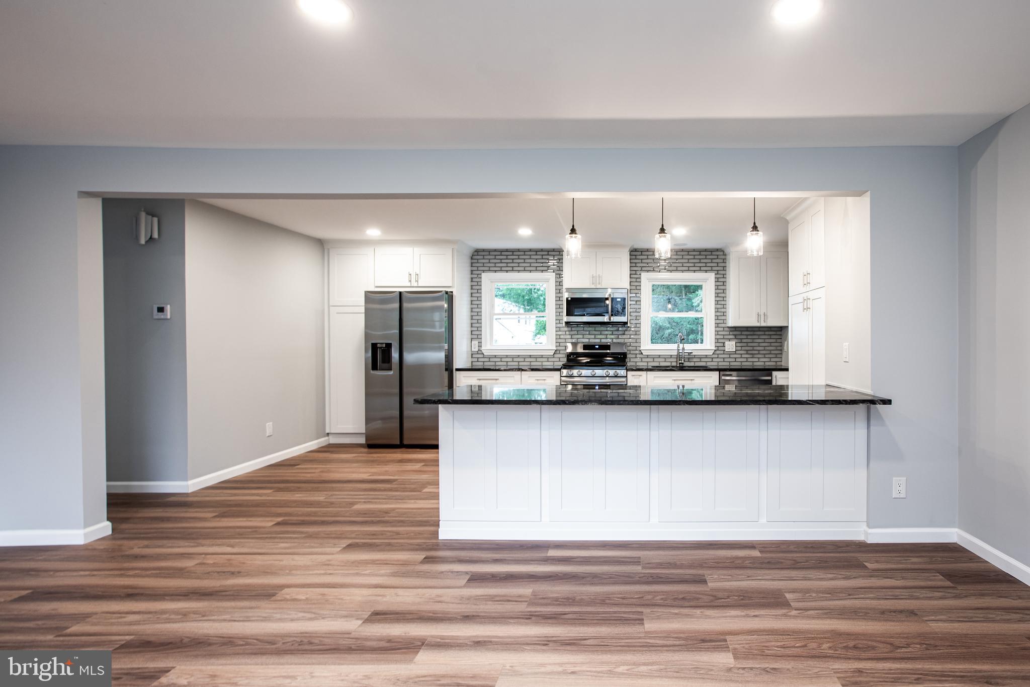 5 Cold Spring Road Hamilton, NJ 08619 - Photo 6 of 33 a view of a kitchen with kitchen island a sink wooden floor and stainless steel appliances