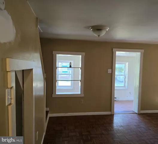 an empty room with wooden floor and a window