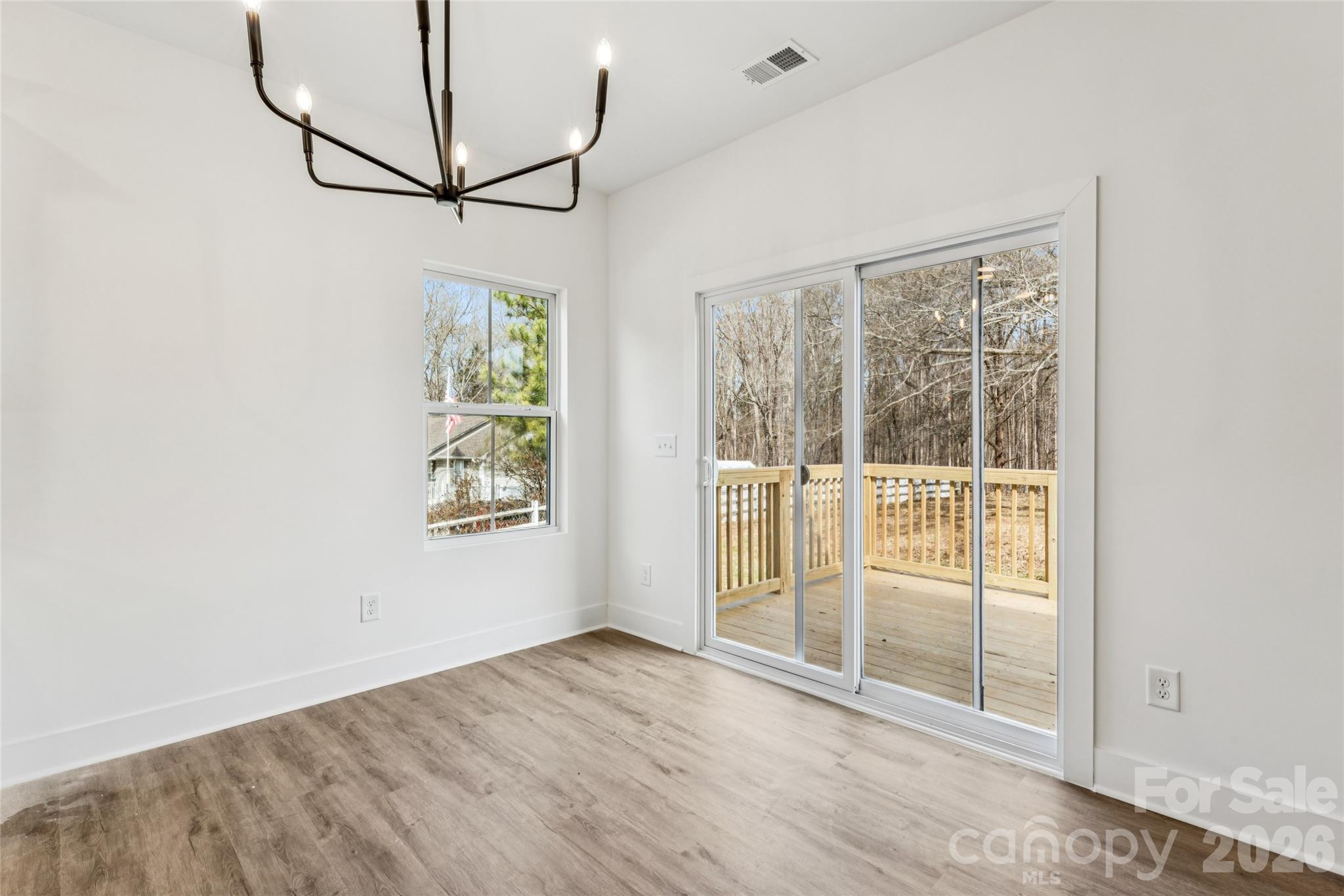 6115 Morehead Road Harrisburg, NC 28075 - Photo 11 of 38 a view of a big room with wooden floor and windows