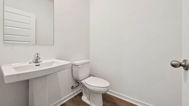 a bathroom with a toilet a sink and mirror