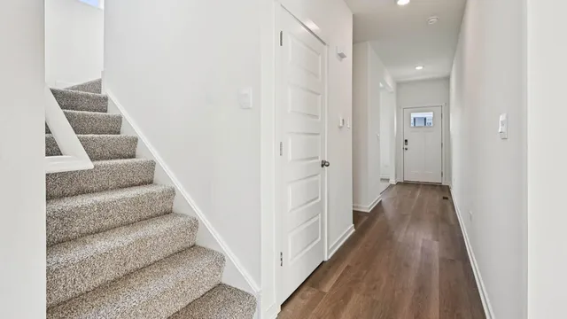 a view of a hallway with wooden floor and staircase