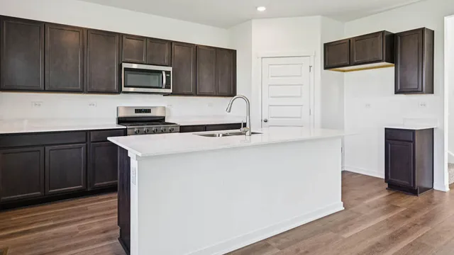 a kitchen with stainless steel appliances a refrigerator stove and microwave