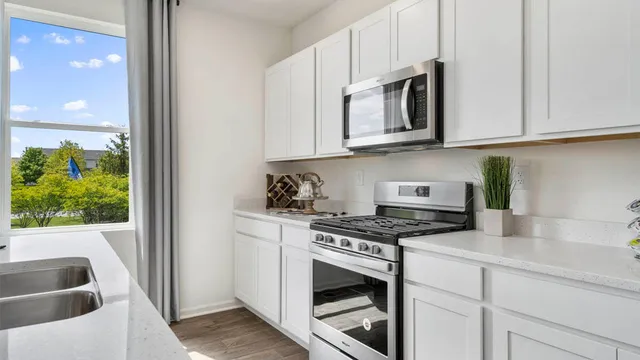 a kitchen with stainless steel appliances granite countertop a sink and a stove