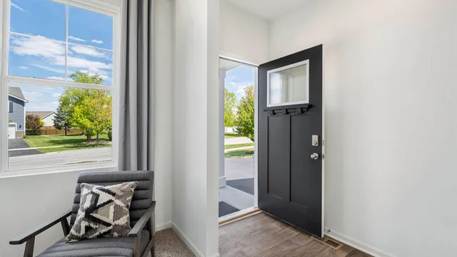 a view of a hallway with furniture and a window