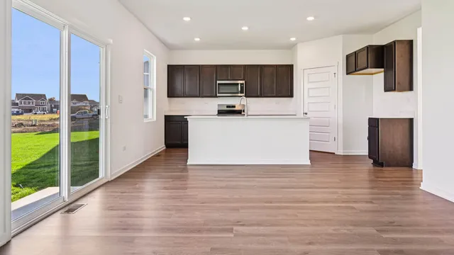 a view of kitchen with stainless steel appliances kitchen island sink and refrigerator