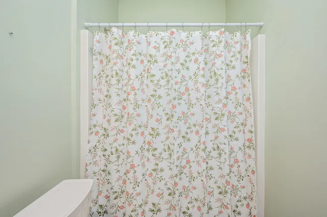 a bathroom with a toilet and a shower curtain