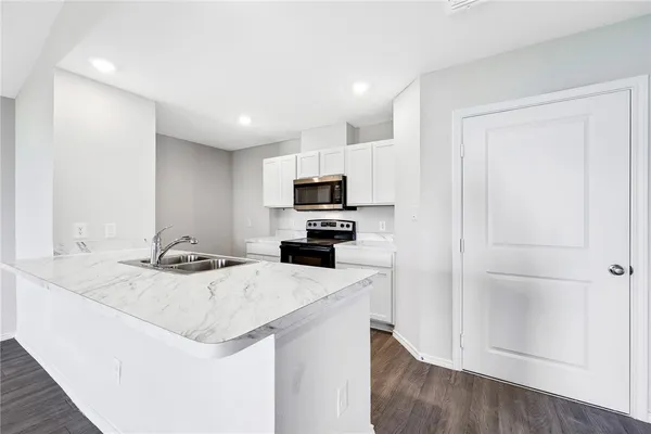 a kitchen with a sink a microwave a stove and refrigerator
