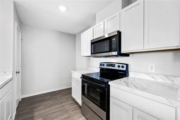 a kitchen with granite countertop wooden cabinets and a stove top oven