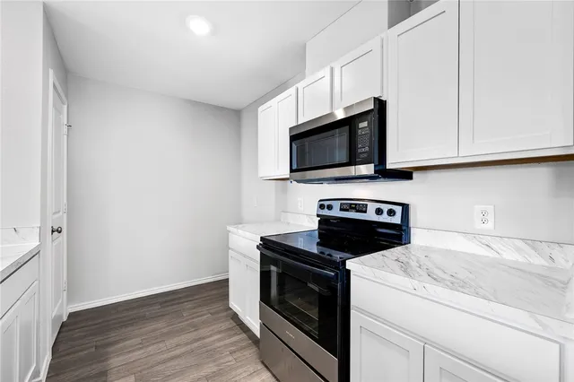 a kitchen with granite countertop wooden cabinets and a stove top oven