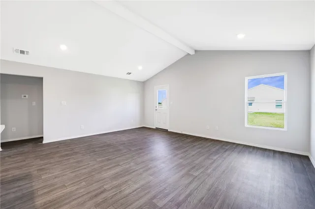 an empty room with wooden floor and window