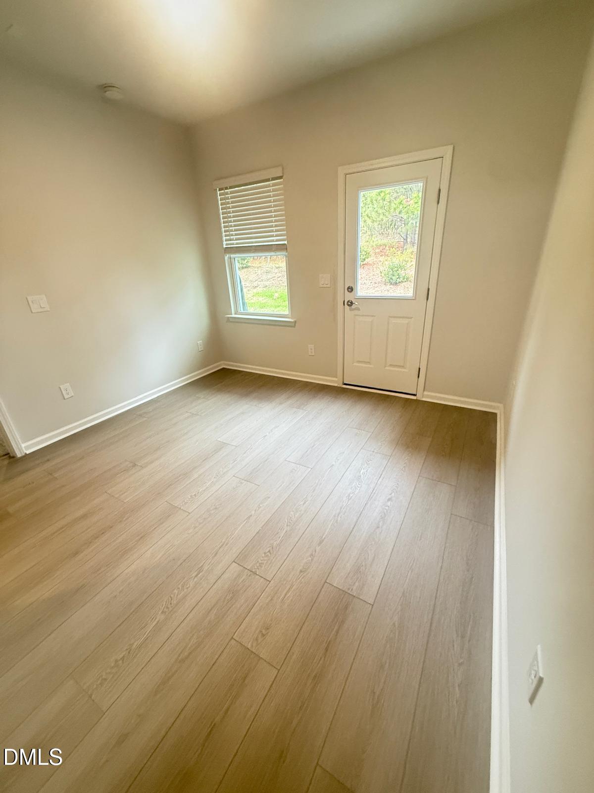 2126 Grubstake Street Apex, NC 27523 - Photo 19 of 22 an empty room with wooden floor and windows