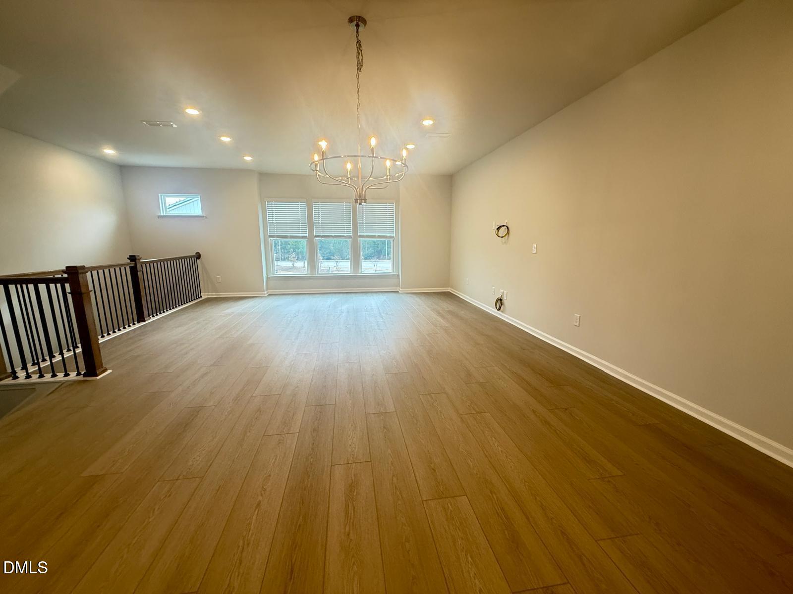 2126 Grubstake Street Apex, NC 27523 - Photo 4 of 22 an empty room with wooden floor and windows