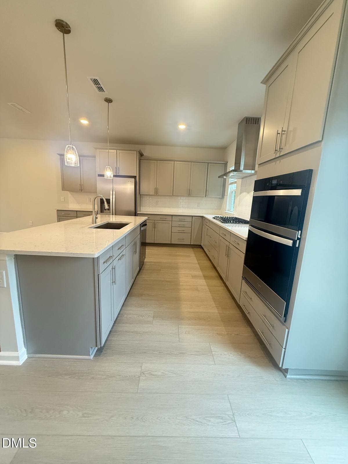 2126 Grubstake Street Apex, NC 27523 - Photo 5 of 22 a large kitchen with a large counter top stainless steel appliances and cabinets