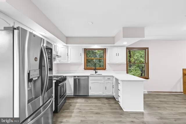 a large kitchen with stainless steel appliances granite countertop a refrigerator and a sink