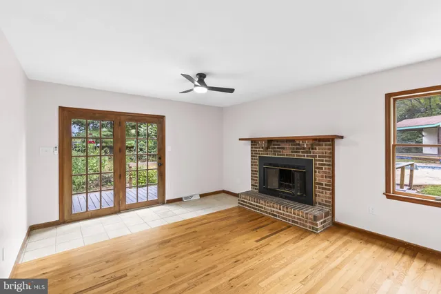 wooden floor fireplace and windows in an empty room