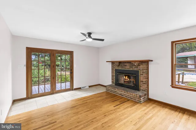 wooden floor fireplace and windows in an empty room