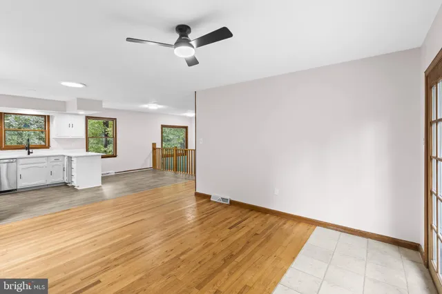 a view of an empty room with a window and wooden floor
