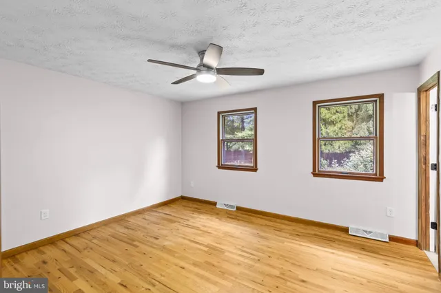 a view of empty room with wooden floor