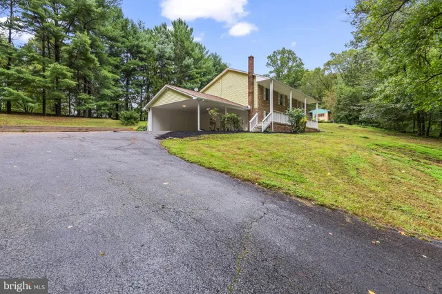 a front view of a house with a yard and trees