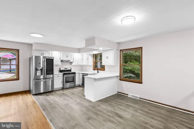a kitchen with a refrigerator and a stove top oven