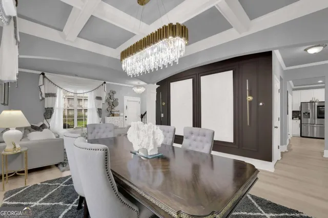 a dining room with furniture a chandelier and wooden floor