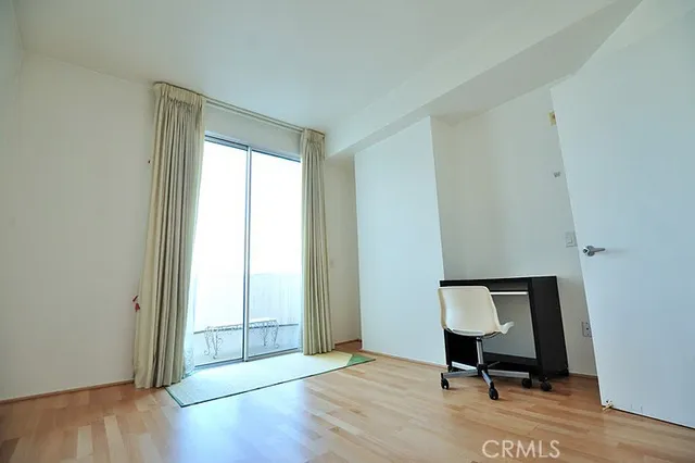 a view of a room with wooden floor lounge chair and windows