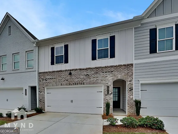a front view of a house with plants