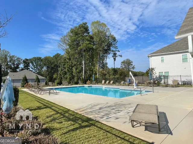 a living room with furniture kitchen view and a chandelier