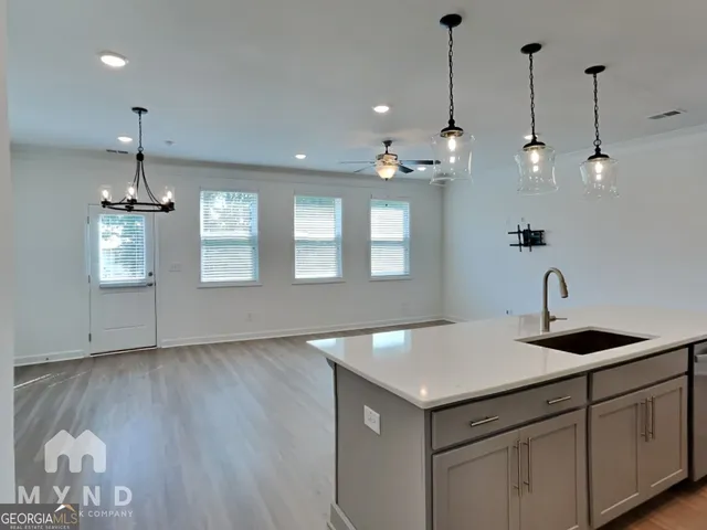 a kitchen that has a lot of cabinets and wooden floor