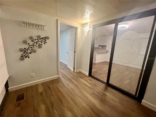an empty room with wooden floor and mirror