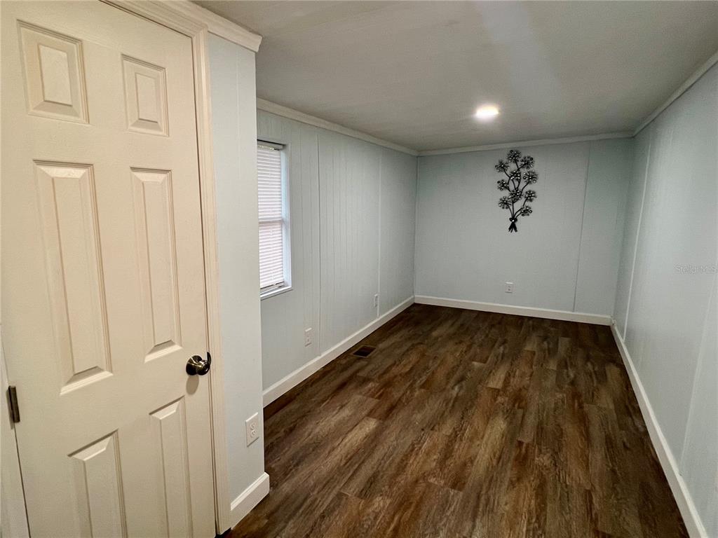 3000 Clarcona Road, Unit 410 Apopka, FL 32703 - Photo 4 of 11 a view of a hallway with wooden floor and entryway