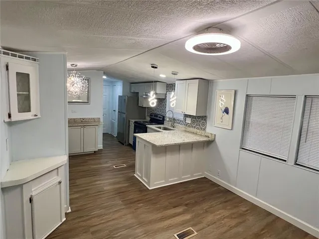 a kitchen with a refrigerator sink and cabinets