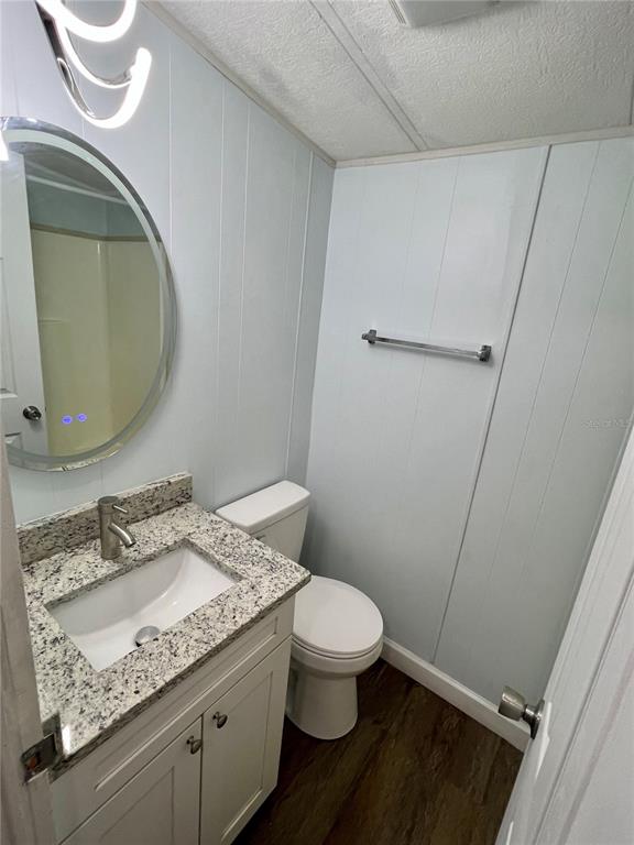 3000 Clarcona Road, Unit 410 Apopka, FL 32703 - Photo 9 of 11 a bathroom with a granite countertop sink a toilet and a mirror
