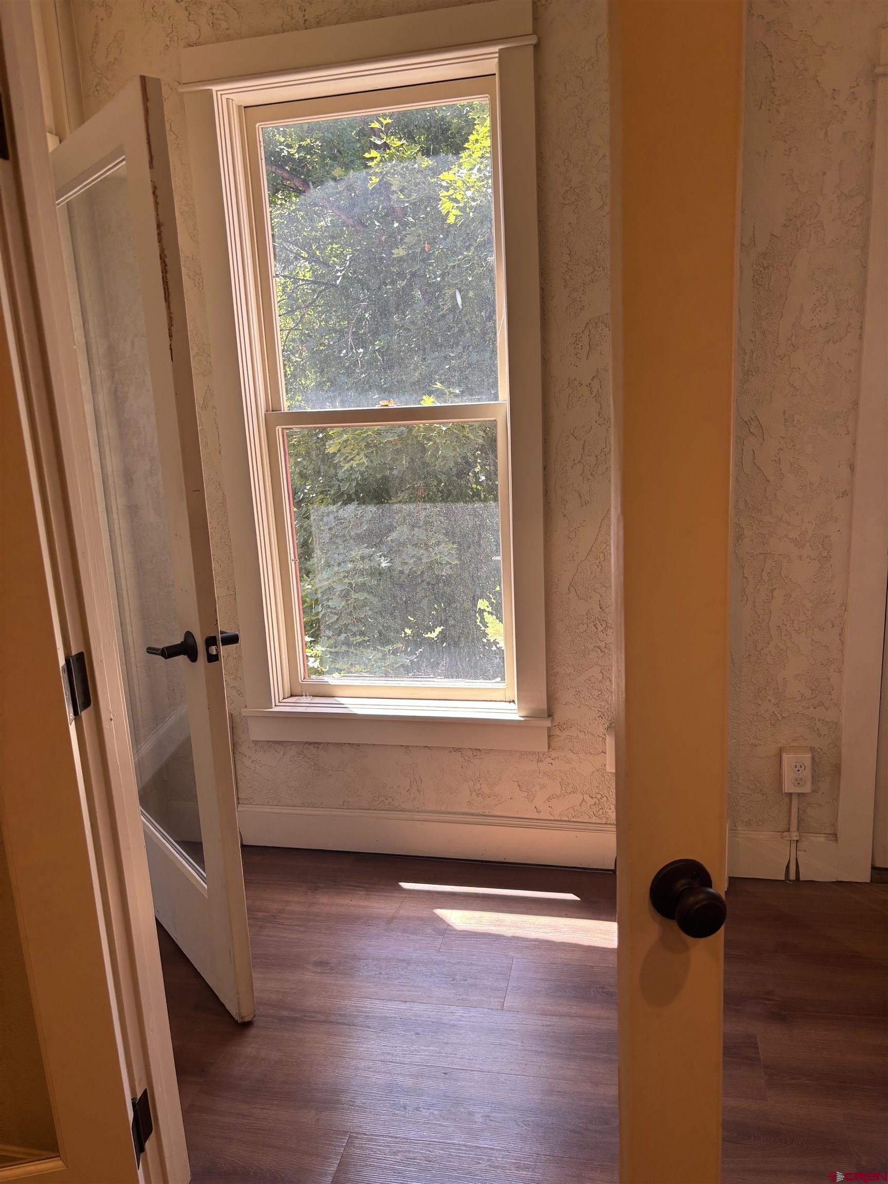 552 Main Avenue, Unit B Durango, CO 81301 - Photo 9 of 12 a view of an empty room with wooden floor and a window