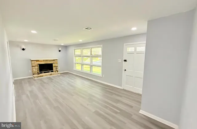 wooden floor fireplace and windows in an empty room