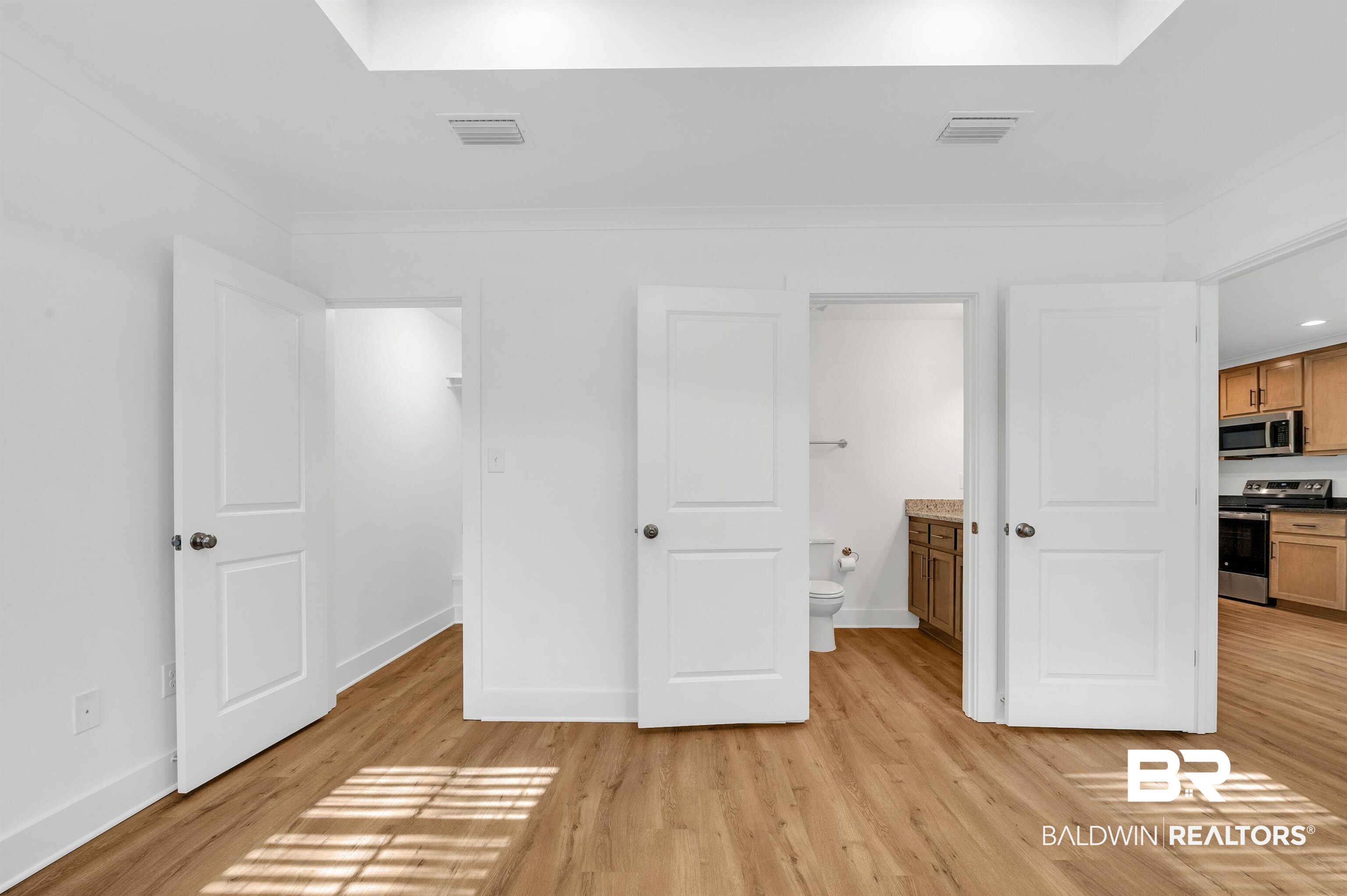 22045 8th Street Silverhill, AL 36576 - Photo 24 of 39 Primary bedroom with light wood finished floors, baseboards, ornamental molding, and ensuite bathroom