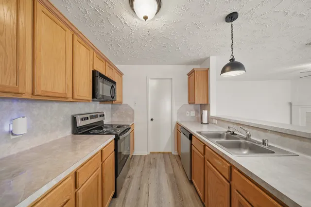 a kitchen with a sink stove and microwave