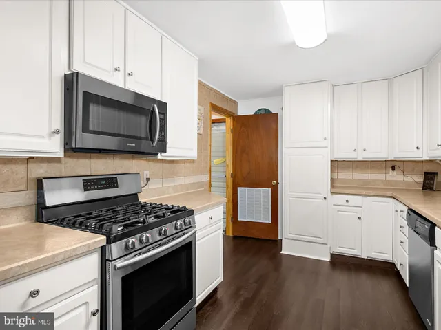 a kitchen with stainless steel appliances granite countertop a stove a refrigerator and a microwave