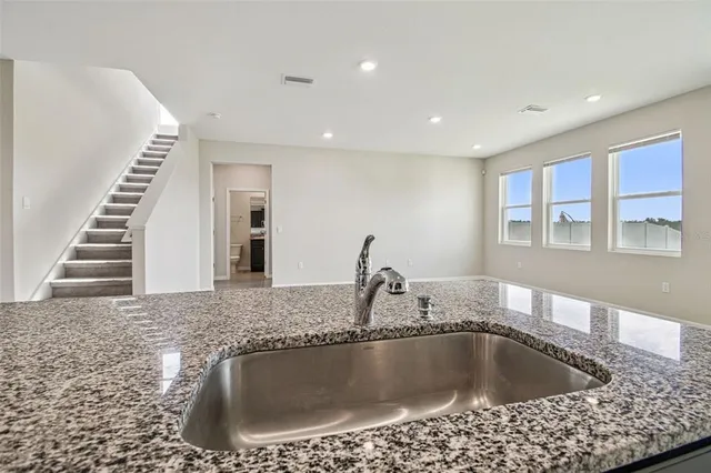 a kitchen with stainless steel appliances granite countertop a sink and a stove