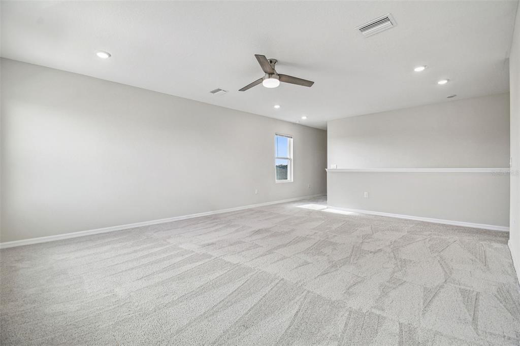 3827 Sunny Spring Street Plant City, FL 33565 - Photo 23 of 57 an empty room with ceiling fan and windows