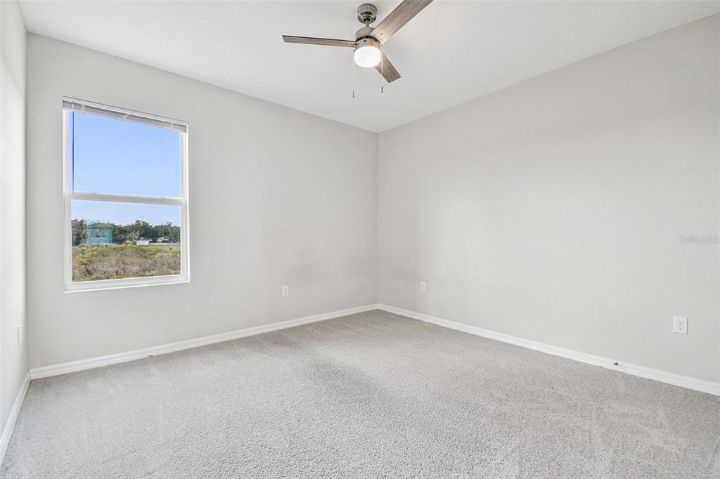 3827 Sunny Spring Street Plant City, FL 33565 - Photo 24 of 57 an empty room with a window and a ceiling fan