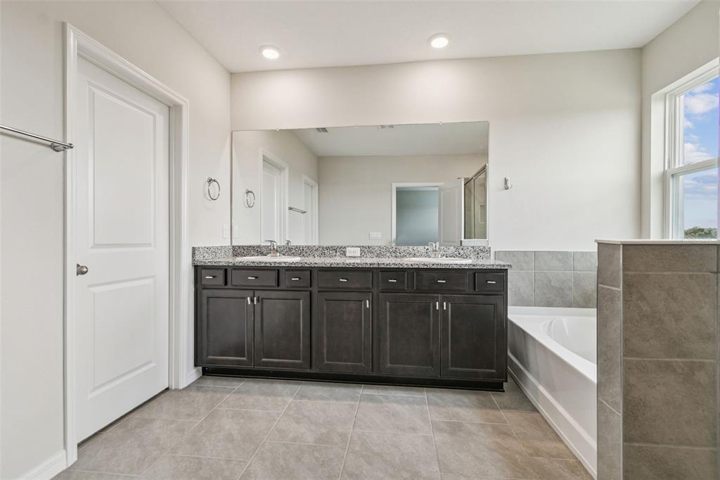 3827 Sunny Spring Street Plant City, FL 33565 - Photo 34 of 57 a bathroom with a granite countertop double vanity sink and a mirror