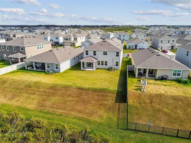 an aerial view of a house with a garden and lake view