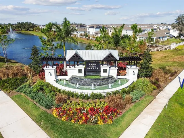 a view of a lake with a yard and large trees
