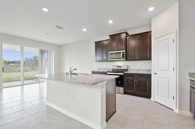 a kitchen with stainless steel appliances a refrigerator and a stove top oven
