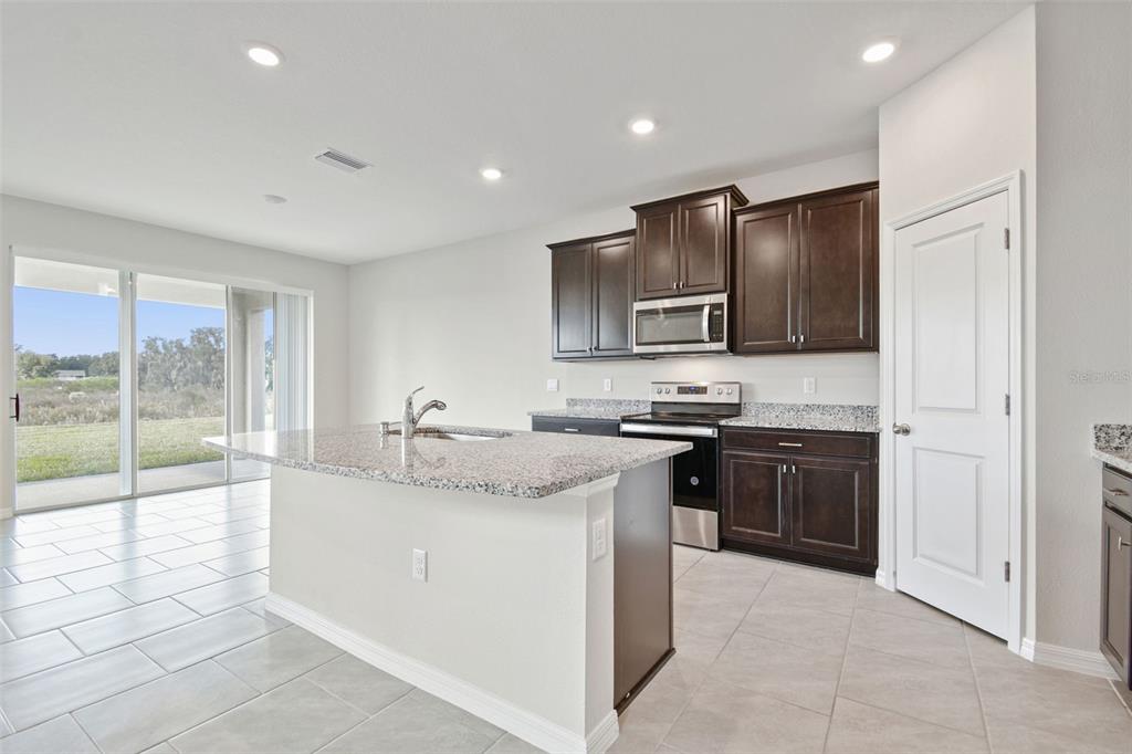 3827 Sunny Spring Street Plant City, FL 33565 - Photo 9 of 57 a kitchen with kitchen island granite countertop appliances cabinets and a sink