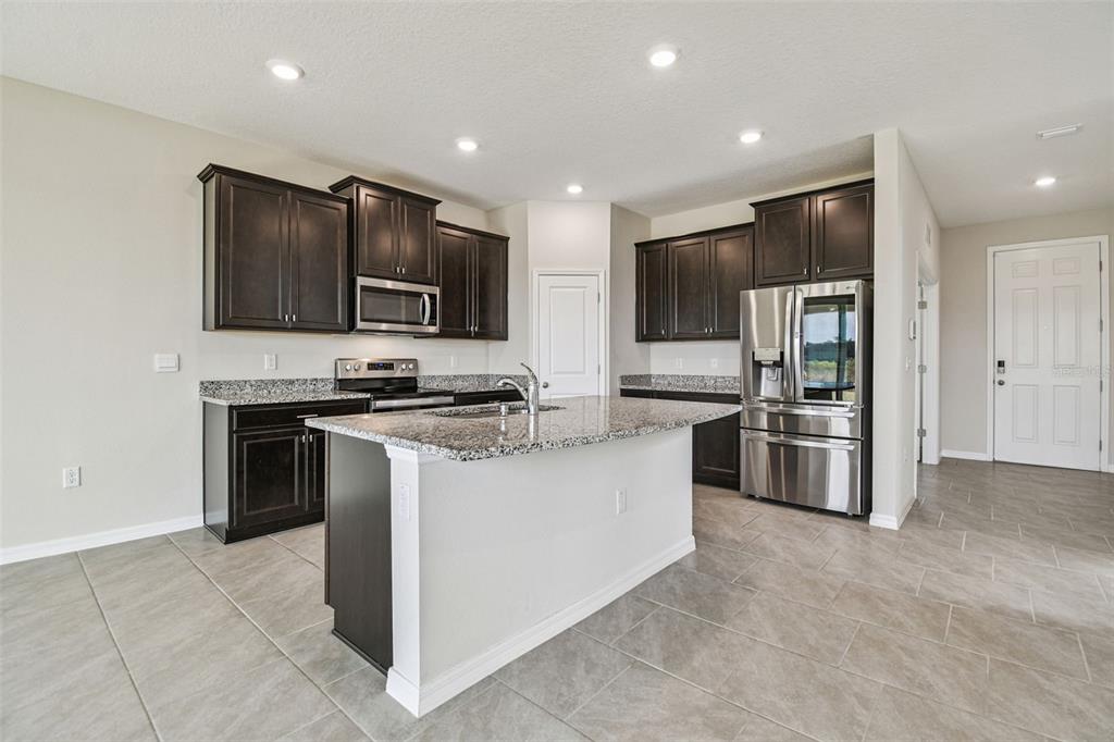 3827 Sunny Spring Street Plant City, FL 33565 - Photo 10 of 57 a kitchen with stainless steel appliances a refrigerator and a stove top oven