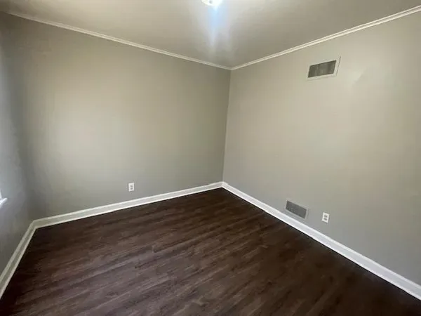 a view of an empty room with wooden floor